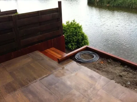 Hardhouten vlonder aan het water met keramische tegels